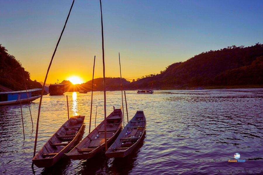 Sunset over Mekong River with boats in Laos – Auasia Travel
